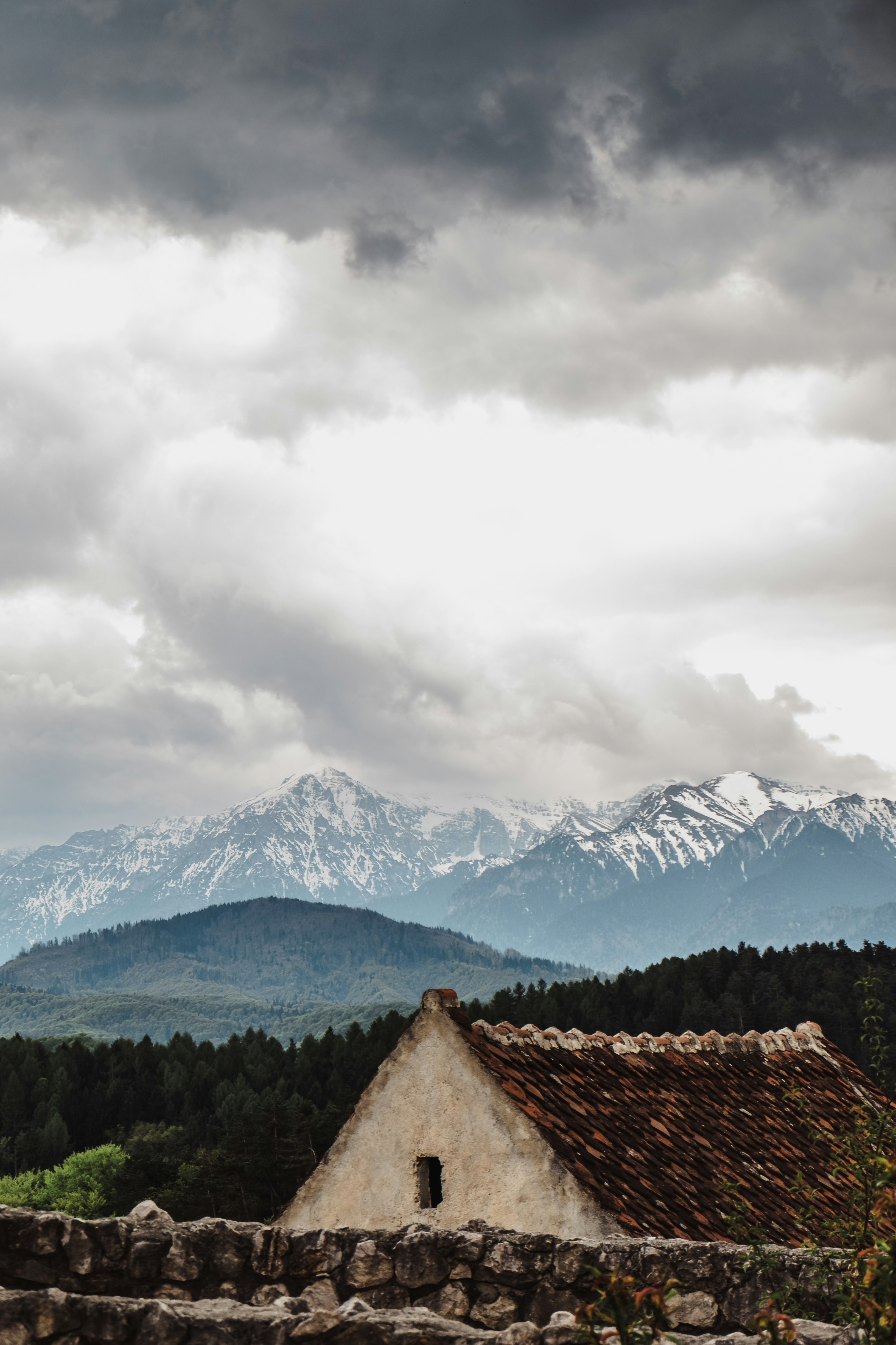 white and brown house near trees and glacier mountains at the distance